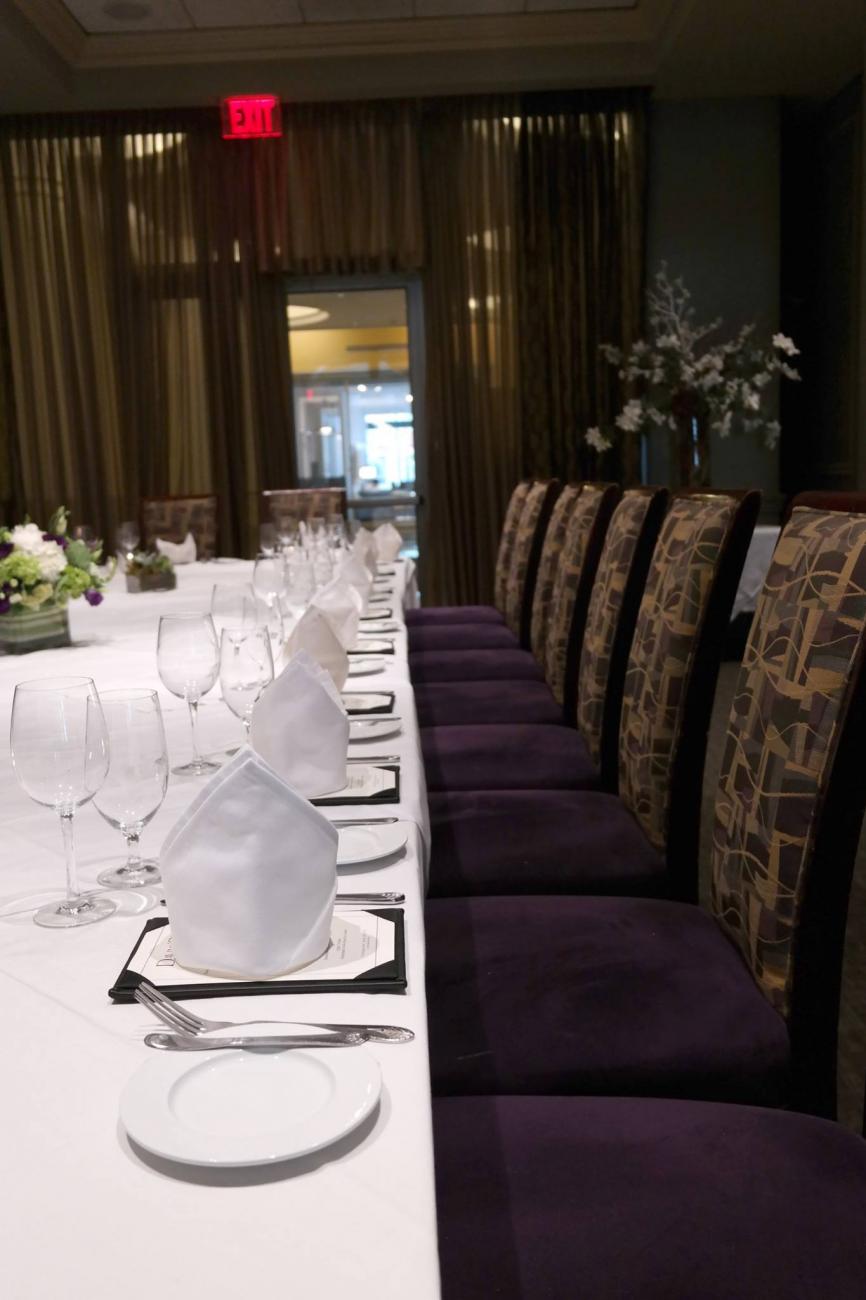 Closeup of a long table set with 7 chairs visible on one side