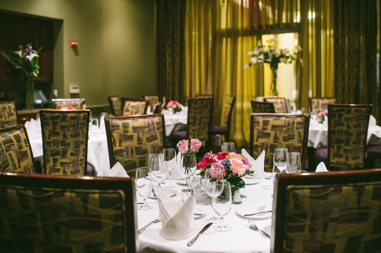 Room set with round tables, white tablecloths, and pink floral centerpieces